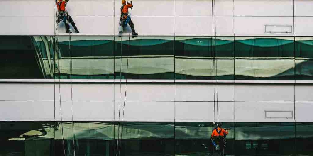 Before – rope access technicians cleaning high-rise building glass facade