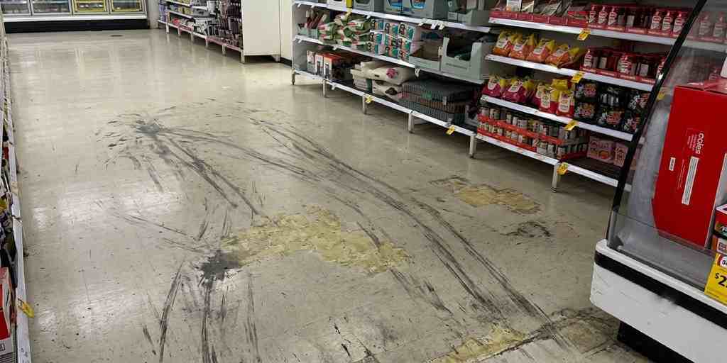 Before – retail aisle vinyl floor with black scuff marks and staining