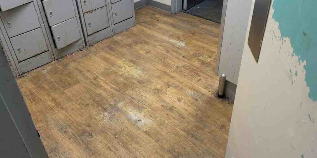 Before – staff locker room vinyl plank floor dirty and worn